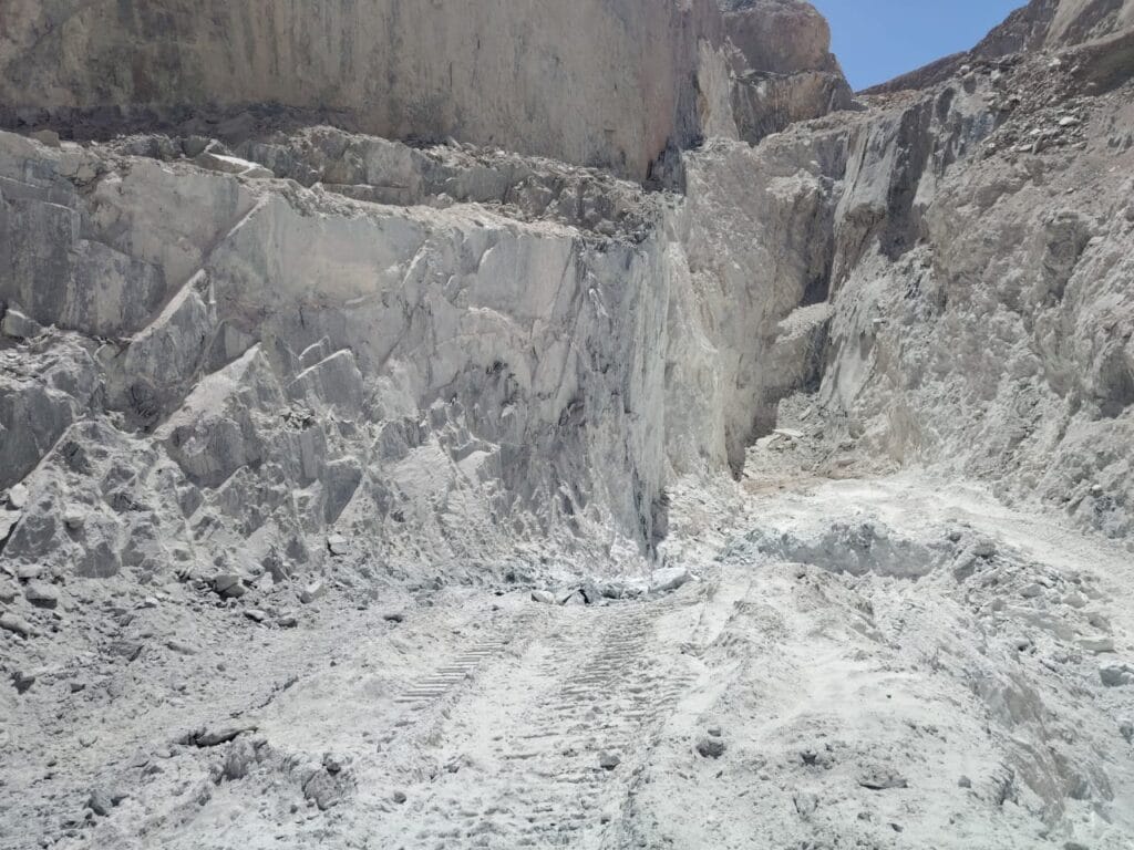 Talc Powder and Feldspar Company - Open-pit mine with light-colored rock formations, potential source of talc powder.