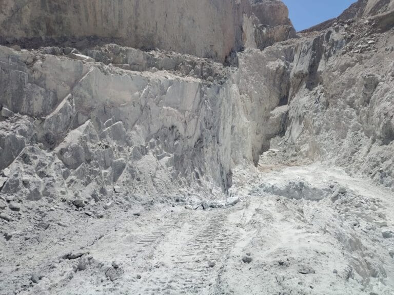 Talc Powder and Feldspar Company - Open-pit mine with light-colored rock formations, potential source of talc powder.